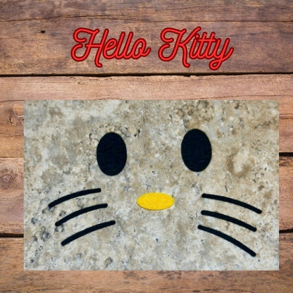 Hello Kitty Felt Face made for That Nerdy Hooker Crochet pattern. Shows 2 black oval eyes, 1 oval yellow nose and 6 black whiskers. 