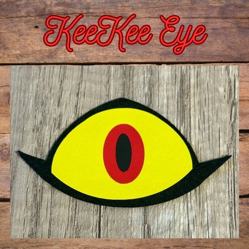 Yellow eye with a red center on a wooden background with 'KeeKee Eye' text.