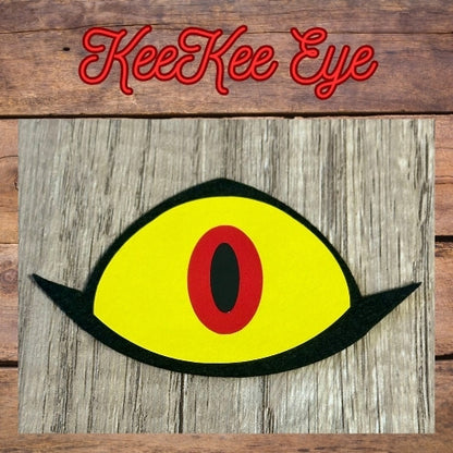 Yellow eye with a red center on a wooden background with 'KeeKee Eye' text.