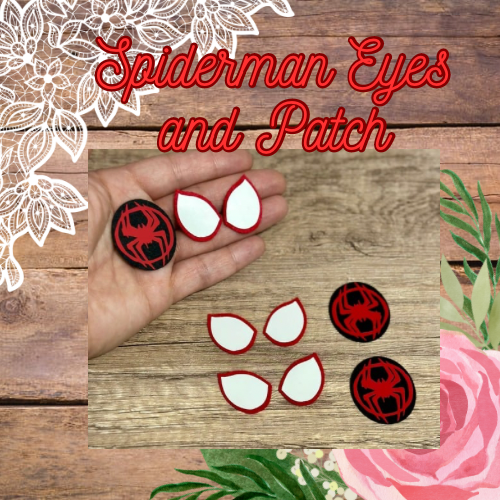 A set of crochet Spiderman eyes and patch, with red and black colors and the Spiderman logo, held in a hand against a wooden background with a floral pattern.